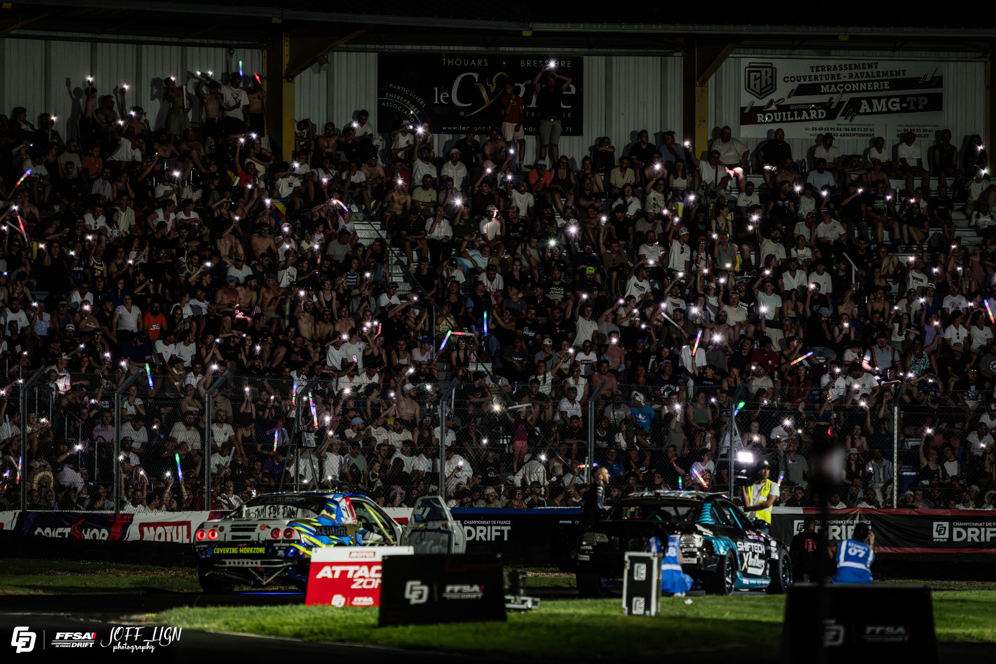 Tribune pleine lors d'une manche de nuit du Championnat de France de Drift, téléphones allumés